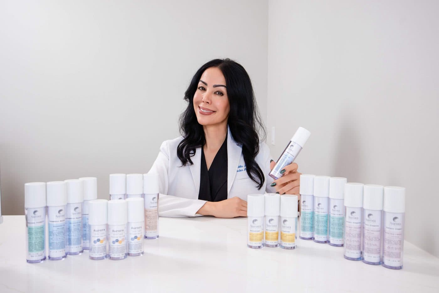 Founder Mahla Morteza in a white coat beside her professional skincare product line