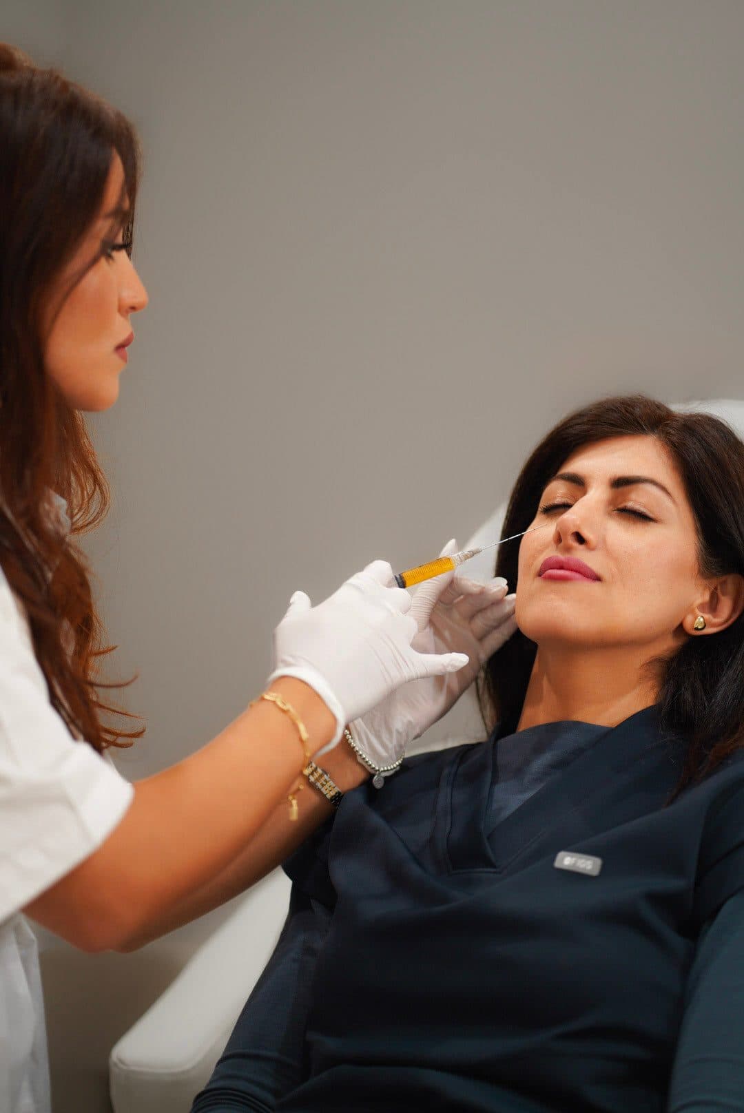 Injector performing a careful lip treatment on a client